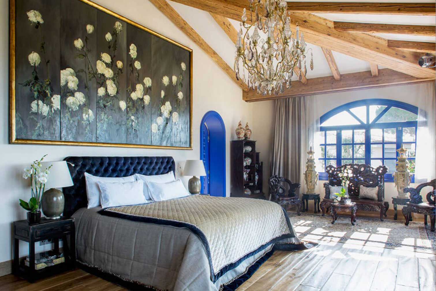 Dormitorio principal con vigas de madera azules y suelo de parquet de roble natural