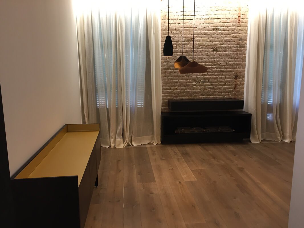 Detalle de salón estilo industrial con parquet ahumado