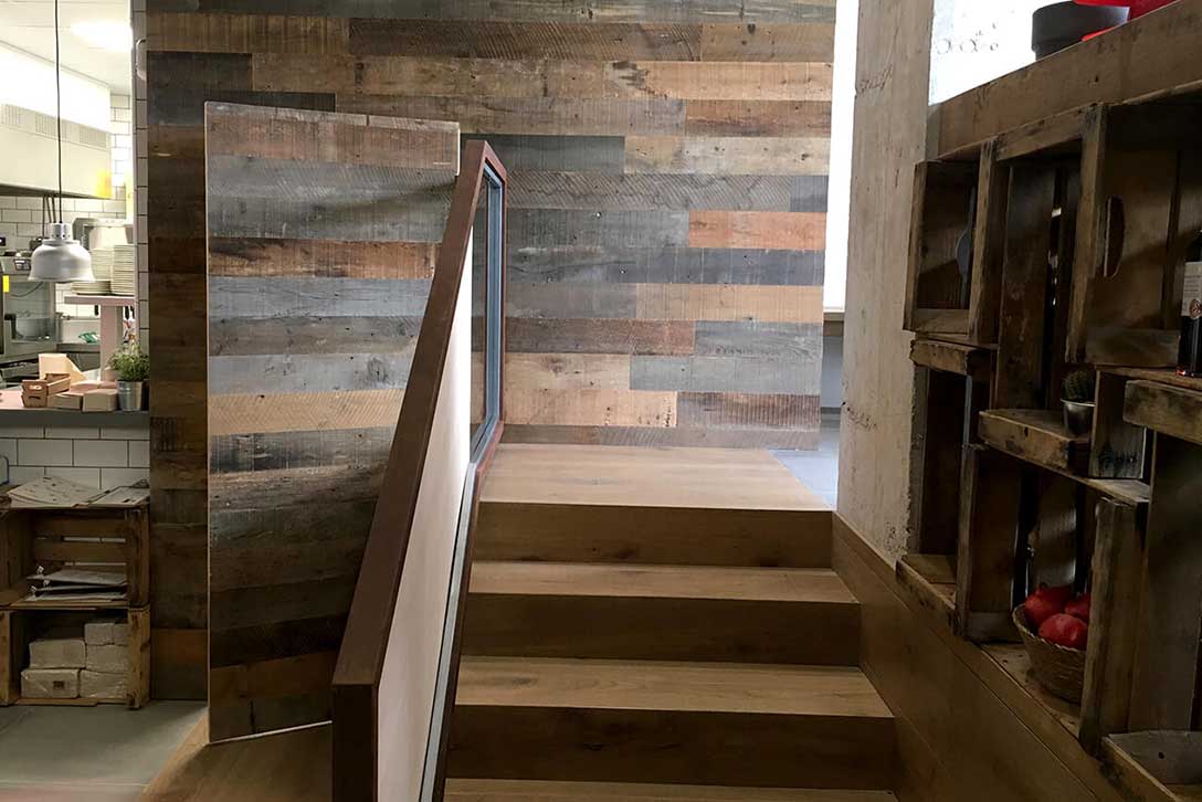 Detail of staircase and wall with aged wood at Restaurant Arrels