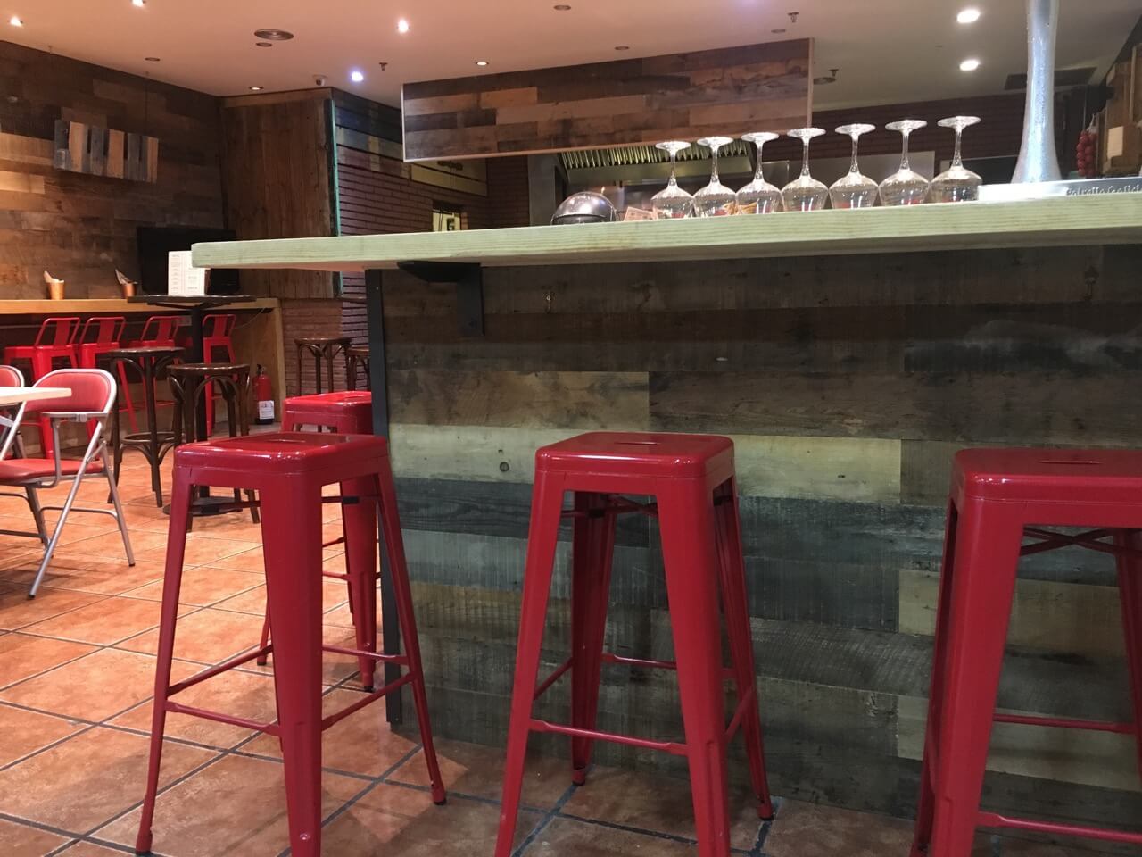 Parquet vertical de fusta reciclada en barra de restaurant a Barcelona, projecte de Moskito Parquets.
