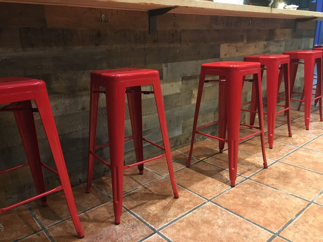 Detall de la barra revestida amb fustes mecanitzades en interior de restaurant a Barcelona.