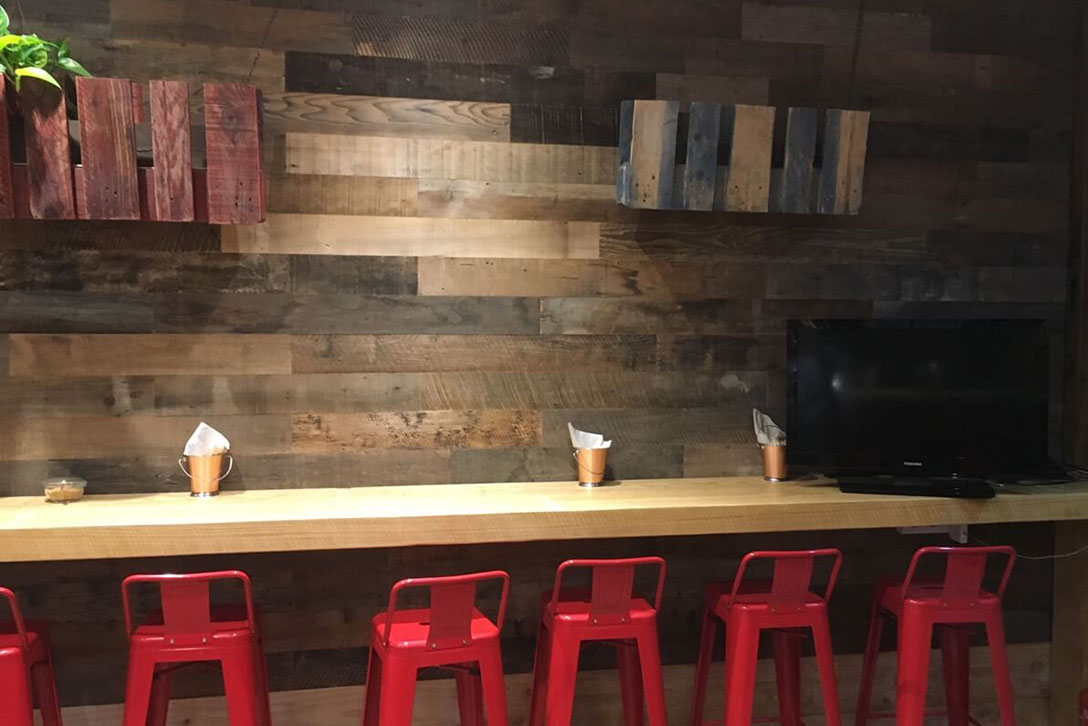 Walls clad with machined natural wood in commercial premises in Barcelona, Moskito project.