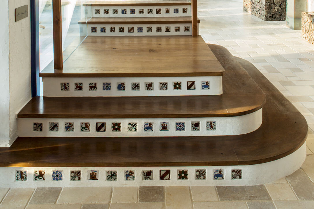 Escalera de madera decorativa con incrustaciones cerámicas en vivienda mediterránea